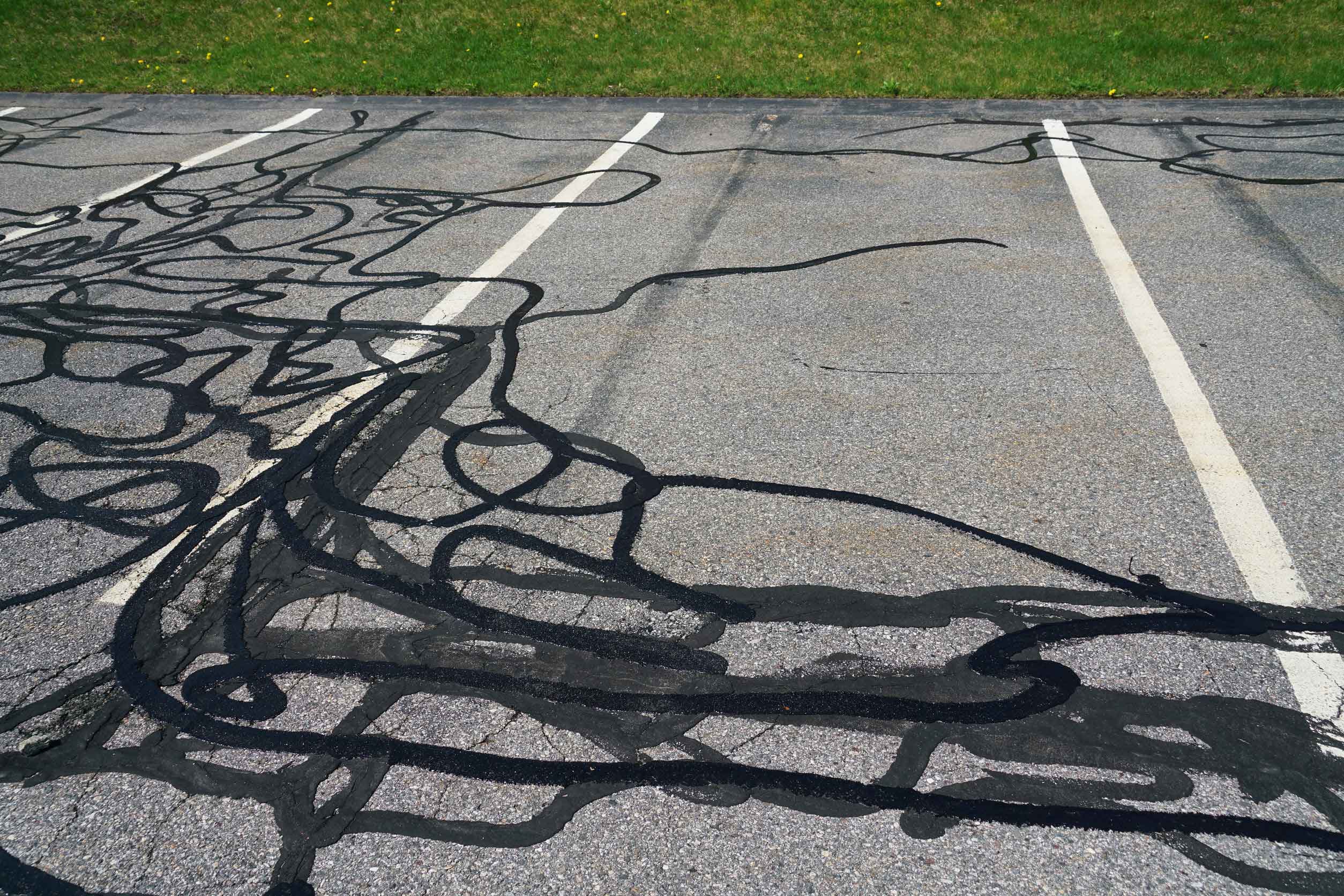 Pattern over parking spaces from cracked asphalt